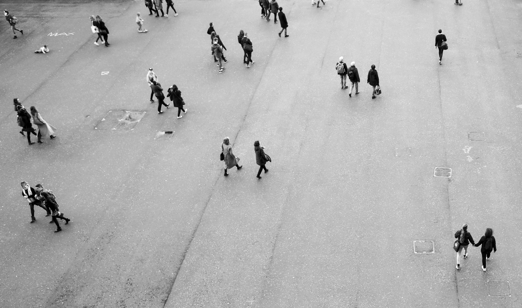 People crossing a wide open square, seen from above